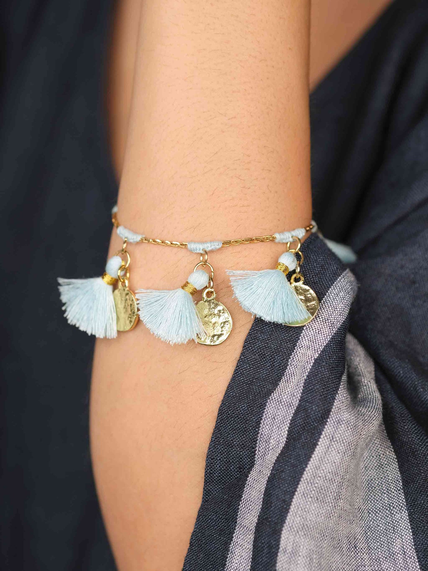 Bohemian glam in gold and candy blue fringe bracelet with stylish coin detailing.